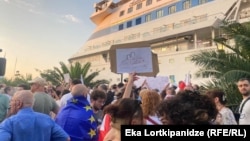 Demonstrators protest the presence of a cruise ship carrying Russian passengers in the Georgian port of Batumi on July 27