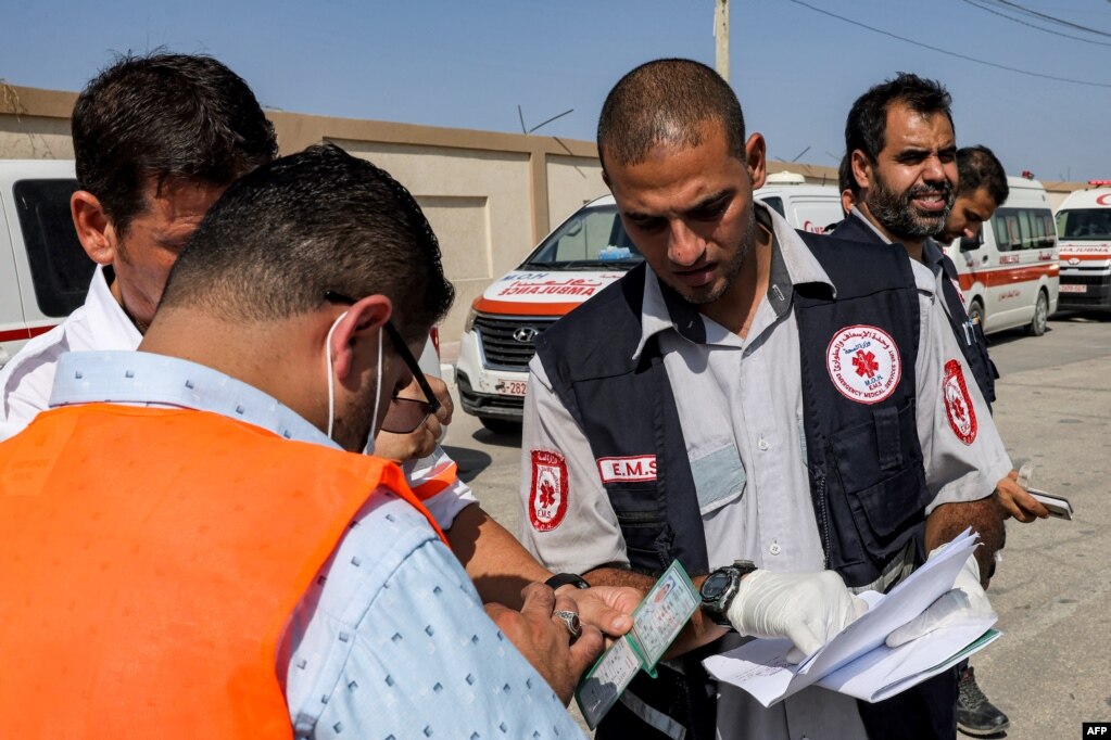 Ndihmësmjekët e Ministrisë palestineze të Shëndetësisë duke kontrolluar dokumentet e udhëtimit të një personi gjatë kalimit në Egjipt në pikën kufitare Rafah në Rripin jugor të Gazës më 1 nëntor 2023. 