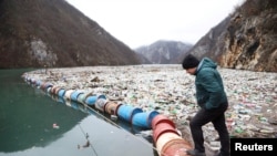 Ekološki aktivista Robert Oroz posmatra plutajuću deponiju smeća u kanjonu rijeke Drine, u blizini grada Višegrada, Bosna i Hercegovina, 5. januara 2024.
