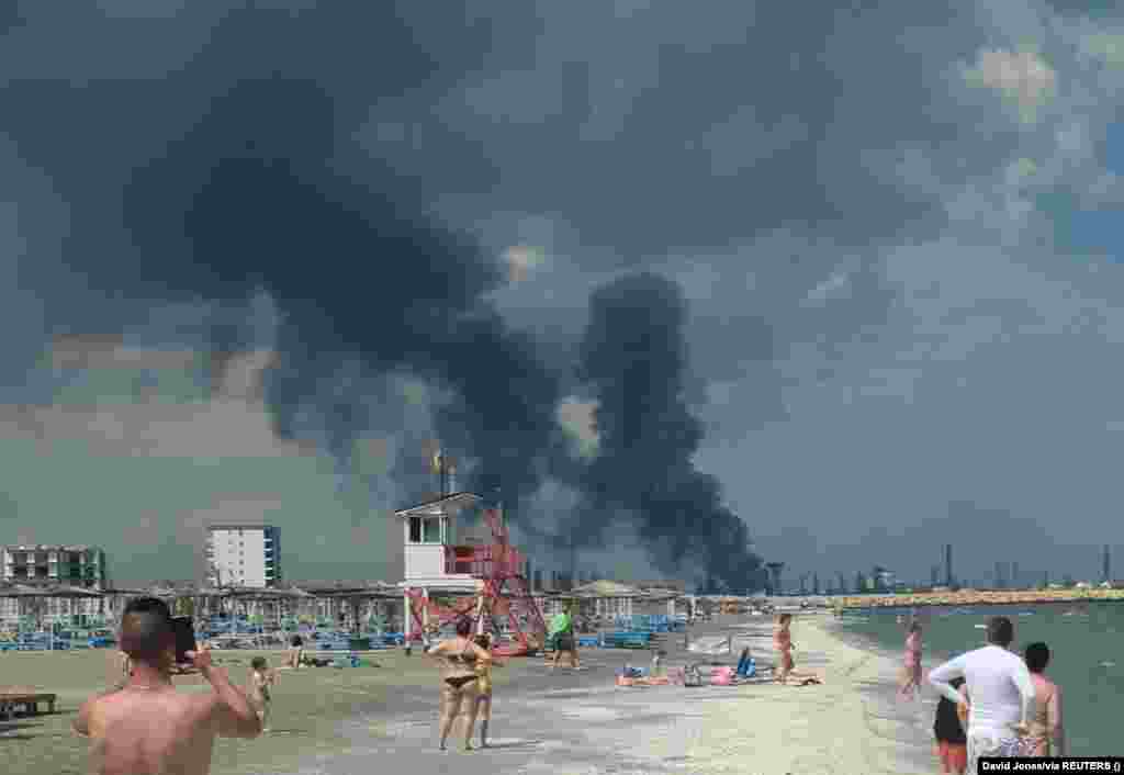 People watch as smoke billows from Romania&#39;s Petromidia&nbsp;oil refinery on the Black Sea coast.