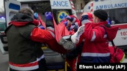 Рятувальники евакуюють пораненого чоловіка після російської атаки в Києві, 23 січня 2024 року