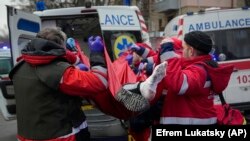 Рятувальники евакуюють пораненого чоловіка після російської атаки в Києві, 23 січня 2024 року