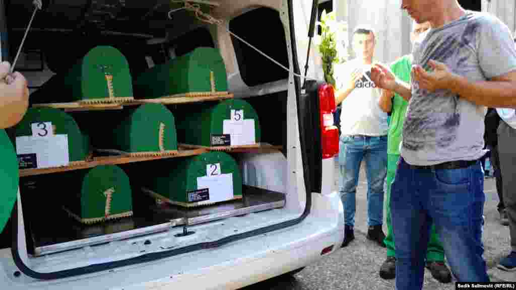 Bosnian men pray near the remains being transported to Potocari. The United Nations General Assembly officially marks July 11 as an International Day of Reflection and Commemoration in honor of those killed in the Srebrenica genocide.&nbsp; &nbsp;