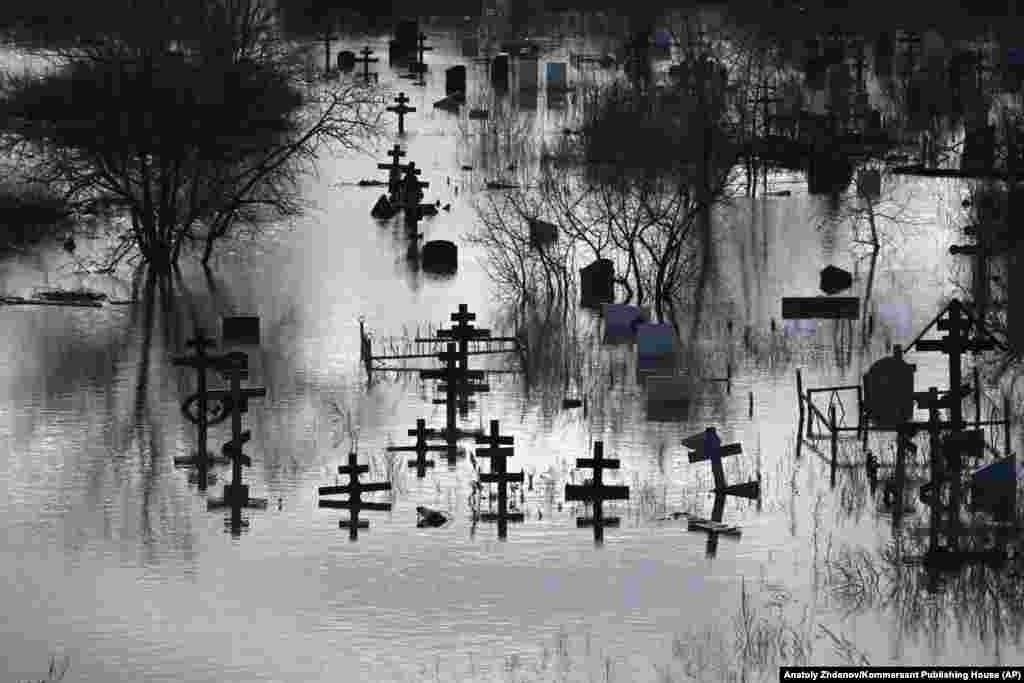 Crosses stand above the floodwaters in a cemetery in Orsk. Regional authorities said they found four people dead in the flood zone. The authorities said two died of heart attacks and one committed suicide. The cause of the fourth death was not specified, but was designated as &quot;natural,&quot; state-owned RIA Novosti reported.