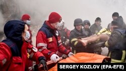 Az ukrán mentők egy orosz rakétatámadás sérültjét emelik ki egy lakóház maradványai közül. A férfi öt órán át volt a romok alatt. 2024. január 23.