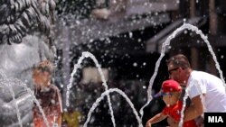 Qytetarë të Shkupit në Maqedoninë e Veriut freskohen në një shatërvan më 19 korrik 2023, kur Evropa është goditur nga një valë e nxehtësisë.