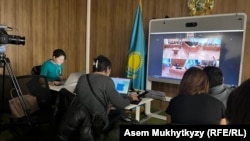 Представители СМИ перед монитором с трансляцией из зала суда. Астана, 11 марта 2024 года