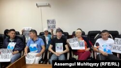 Сторонники активиста Ерулана Амирова в зале суда с плакатами с призывами освободить его. 21 августа 2023 года