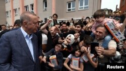 Recep Tayyip Erdoğan își salută suporterii după ce a votat, pe 14 mai 2023.