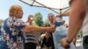 Apă potabilă, pusă la dispoziția trecătorilor la intersecția bulevardului Ștefan cel Mare și Sfânt cu strada Armenească, iulie 2024. Medicii recomandă hidratarea suficientă pe timp de caniculă.