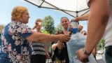Apă potabilă, pusă la dispoziția trecătorilor la intersecția bulevardului Ștefan cel Mare și Sfânt cu strada Armenească, iulie 2024. Medicii recomandă hidratarea suficientă pe timp de caniculă.