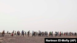 Contrabandiștii îi conduc pe migranții etiopieni pein Obock, Djibouti, către granița cu Arabia Saudită