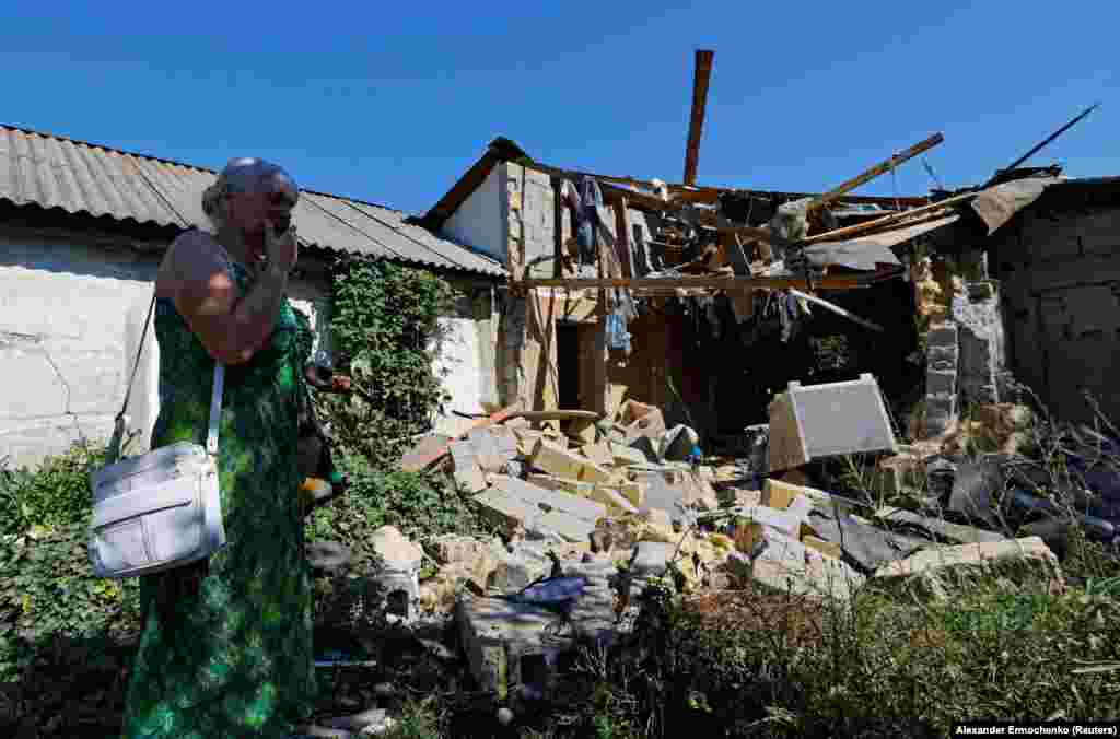 Lyubov Tolchina, 63, reacts next to the damaged house of her son Vitaly, 40, who was killed the day before by shelling in Donetsk, Russian-controlled Ukraine.