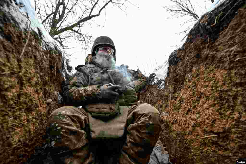 Një ushtarak ukrainas tymos duhan teksa mban një pozicion në llogore në rajonin Zaporizhia, Ukrainë, 14 janar 2024.