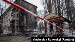 Dio rakete leži na zemlji u blizini stambene zgrade oštećene u ruskom raketnom napadu u Kijevu, 23. januara 2024.