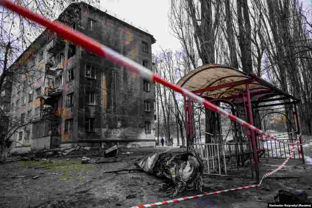 Part of a missile lies on the ground near a damaged apartment building in Kyiv. &nbsp;
