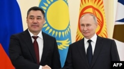 Президент Киргизстану Садир Жапаров (зліва) тисне руку президенту Росії Володимиру Путіну під час Євразійського економічного форуму у Санкт-Петербурзі 25 грудня 2023 року