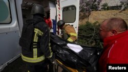 ფოტო არქივიდან. მაშველებს და მედიკოსებს მიაქვთ ხარკოვის ოლქში, საცხოვრებელ რაიონში რუსეთის სარაკეტო დარტყმის შედეგად დაღუპულის ცხედარი. 2023 წლის მაისი 