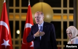 Президент Турции Реджеп Тайип Эрдоган вместе со своей супругой Эмине Эрдоган обращается к сторонникам в Президентском дворце в Анкаре после объявления о его победе во втором туре выборов. Ночь с 28 на 29 мая 2023 года