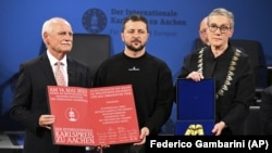 Ukrainian President Volodymyr Zelenskiy (center) receives the Charlemagne Prize for Services to European Unity from Aachen Mayor Sibylle Keupen (right) in Aachen, Germany, on May 14.