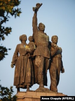 The central figures of the Sofia monument show blue and yellow splashes from a paint-dropping drone attack.