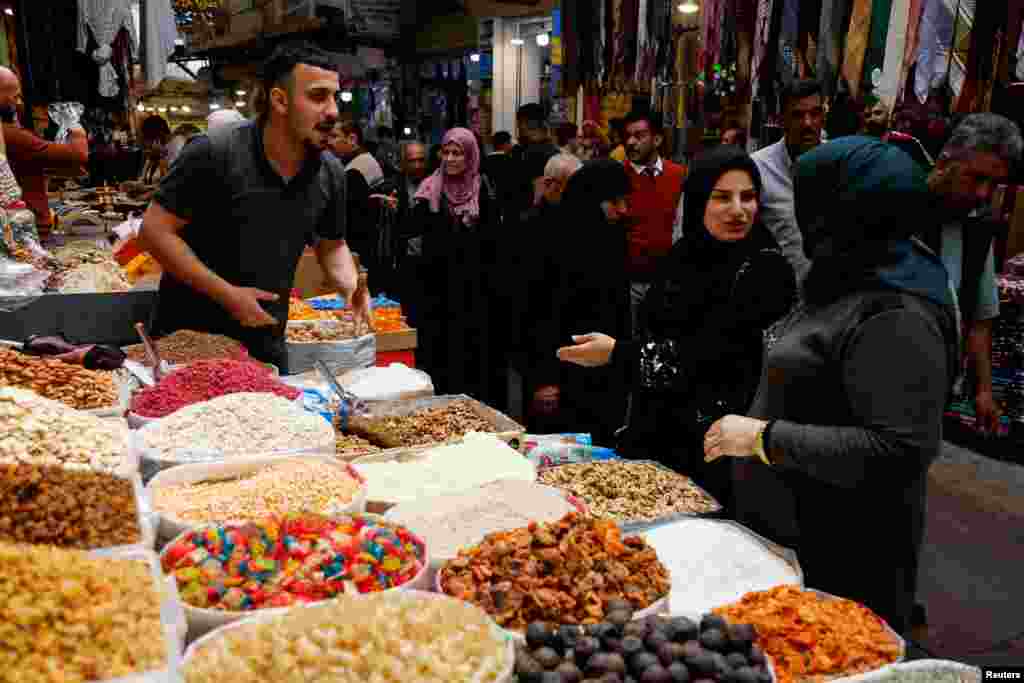 Njerëzit në një treg me shumicë furnizohen me ushqime për muajin e shenjtë të Ramazanit, mes çmimeve në rritje të mallrave, në Mosul, Irak.