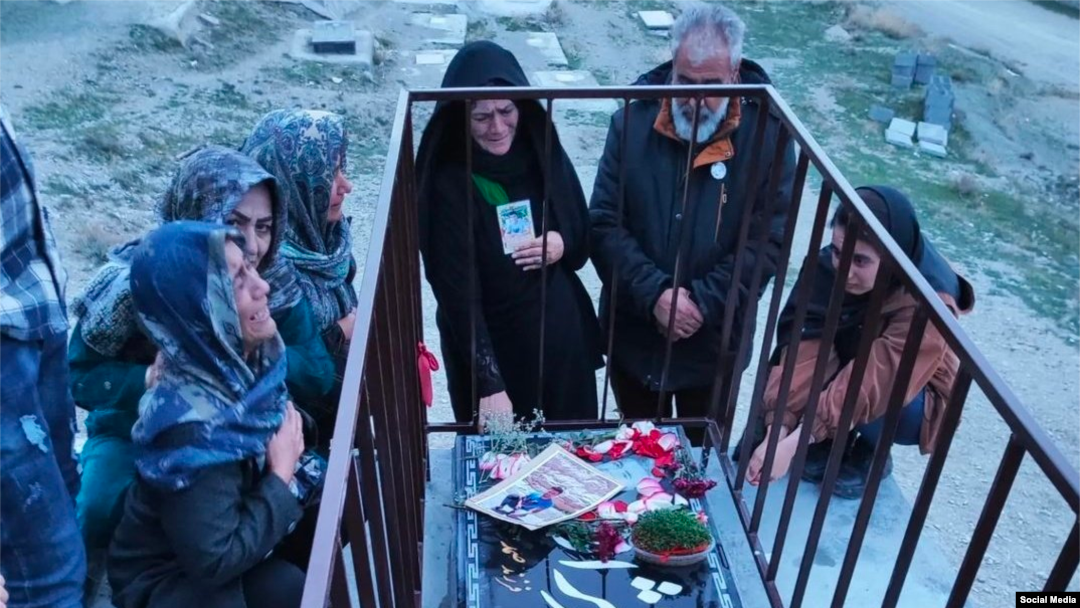 Mourners at the grave of Mehdi Babrinejad who was killed by Iranian security forces during protests last year. 
