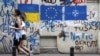 Две жени минават покрай графит с украинското знаме, знамето на ЕС и НАТО в Тбилиси, Грузия, 22 май 2023 г. Снимката е илюстративна.