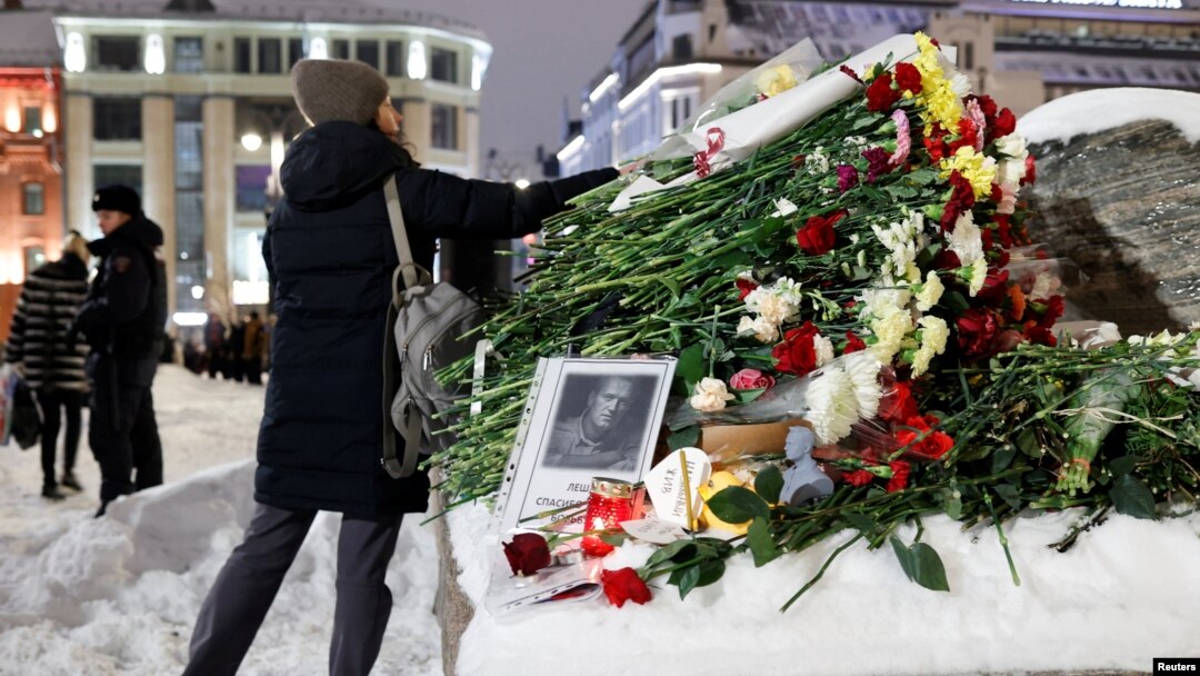 Жена полага цветя на паметника на жертвите на политическите репресии след смъртта на руския опозиционен лидер Алексей Навални, в Москва, Русия, 16 февруари 2024 г.