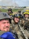 RUSSIA – Members of Russian Volunteer Corps pose for a picture atop an armoured vehicle at Graivoron border crossing in Kozinka, Belgorod region, Russia, in this handout picture released on May 23, 2023