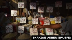 A vendor arranges a price sign at a market in Karachi, Pakistan, on June 26. 