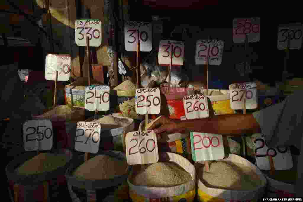 A vendor arranges a price sign at a market in Karachi, Pakistan.