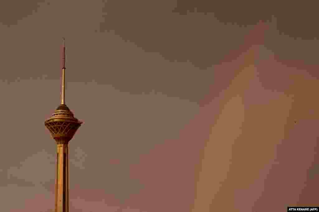 A rainbow is seen behind Milad Tower amid a windy rainstorm in Tehran.