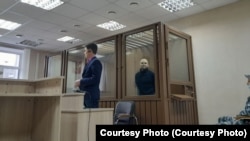 Nyikita Tuskanov a bíróságon a vádlottaknak kialakított ablakos cellában
