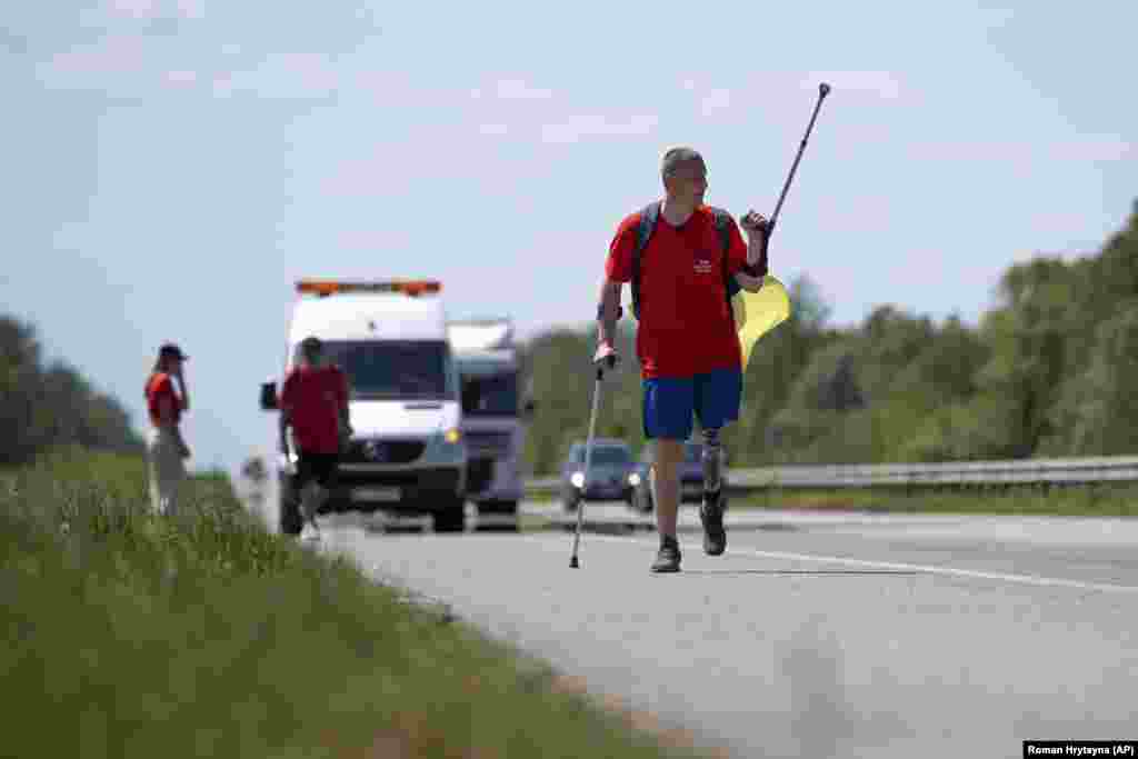 Ukrainian war veteran Oleksandr Shvetsov, 38, walks along a highway from Zhytomyr toward Kyiv on May 18. He will meet fellow veteran Serhiy Khrapko along the road as the pair walk toward each other covering a total of 120 kilometers and racking up 165,000 steps over five days.