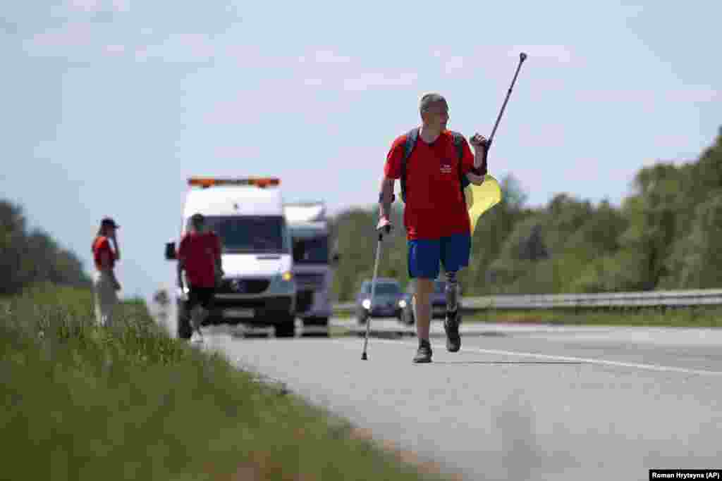 Veterani ukrainas i luftës, Oleksandr Shvetsov, 38 vjeç, duke ecur përgjatë autostradës nga Zhytomiri në drejtim të Kievit më 18 maj. Ai do të takojë kolegun veteran, Serhiy Khrapko, përgjatë rrugës, ndërsa dyshja ecin drejt njëri-tjetrit duke kaluar gjithsej 120 kilometra dhe duke bërë 165.000 hapa për pesë ditë për të mbledhur fonde.