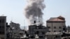 Дим се издига над сгради в град Рафах в южната част на Ивицата Газа по време на израелска бомбардировка, 21 април 2024 г.