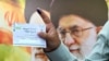A man holds up a ballot during the first round of Iran's presidential election on June 28.