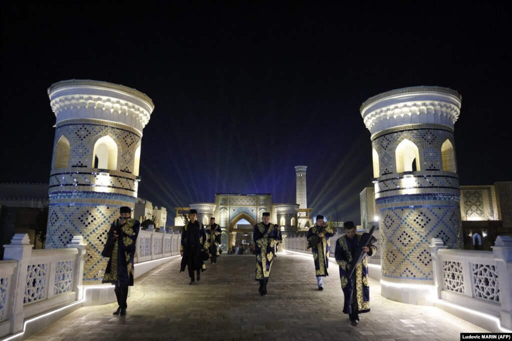Muzikantë dhe valltarë uzbekë duke u larguar pas përfundimit të një ceremonie mirëseardhjeje për presidentin francez, Emmanuel Macron, në Samarkand.
