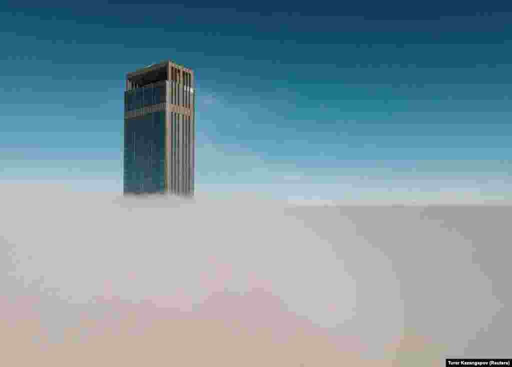 A tower of Abu Dhabi Plaza sticks out of a blanket of thick fog in Astana, Kazakhstan.
