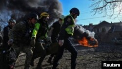 Рятувальники несуть поранену жінку після російського ракетного удару по Запоріжжю, 5 квітня 2024 року