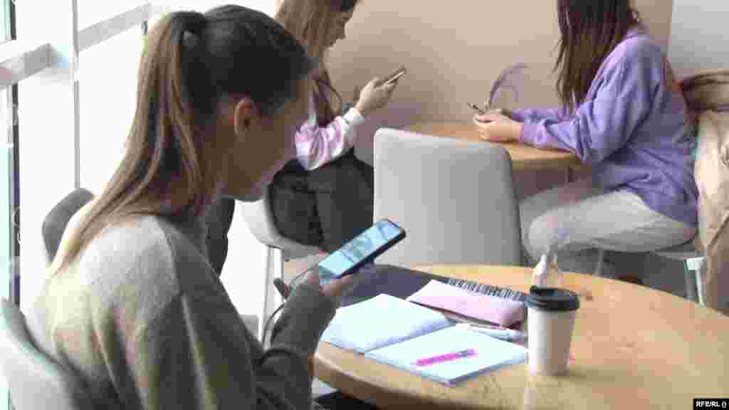 Teenagers make use of their cell phones as they are charged with generators.