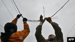 Ukrainian railroad workers repair a damaged power line after a strike in the eastern town of Druzhkivka in March.