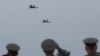 Military personnel watch as Eurofighter Typhoon jets fly over the newly rebuilt air base in Kucova, Albania, on March 4.