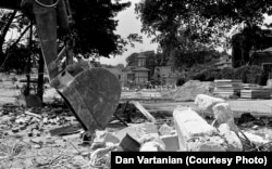 An excavator demolishes homes in the Uranus neighborhood.