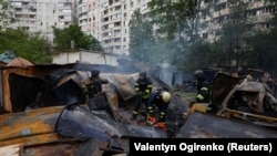 Пожарные работают на месте российского авиаудара в Харькове.