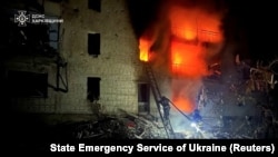 Pompieri ucraineni luptă cu un incendiu izbucnit la o clădire de locuințe în urma unui atac rusesc. 12 martie 2024.
