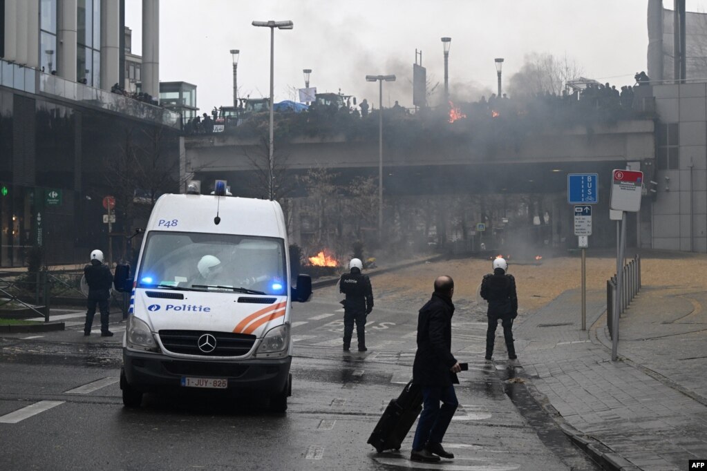 Një këmbësor kalon pranë oficerëve të policisë belge gjatë një proteste të thirrur nga organizatat e fermerëve më 26 shkurt 2024.