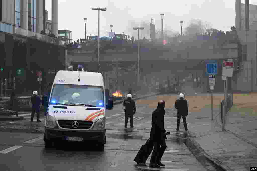 Pješak prolazi pored pripadnika belgijske policije tokom protesta koje su sazvale organizacije poljoprivrednika 26. februara 2024.