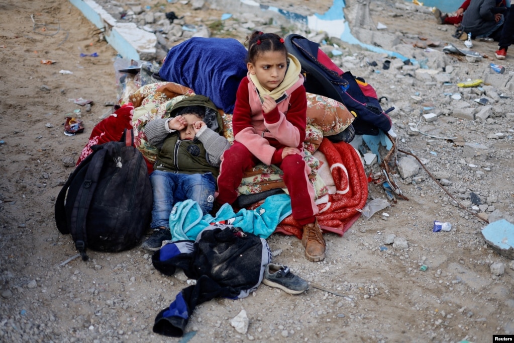 Dy fëmijë qëndrojnë pranë disa valixheve në Rafah, pasi janë evakuuar nga spitali Nasser në Han Junis mes sulmeve të vazhdueshme izraelite, 15 shkurt 2024.&nbsp;